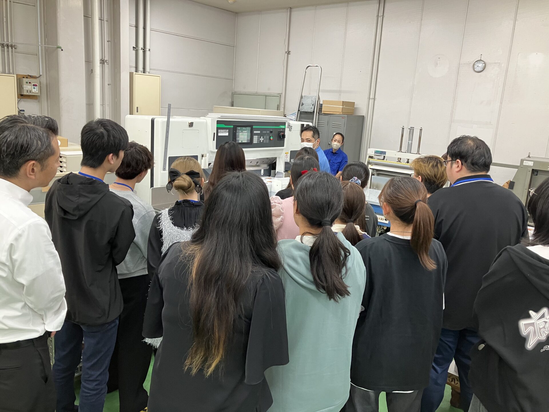 学生に印刷機械の説明している写真
