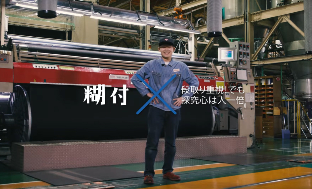 カイハラ株式会社の採用動画のワンシーン。糊付を担当している社員が笑顔で立っている