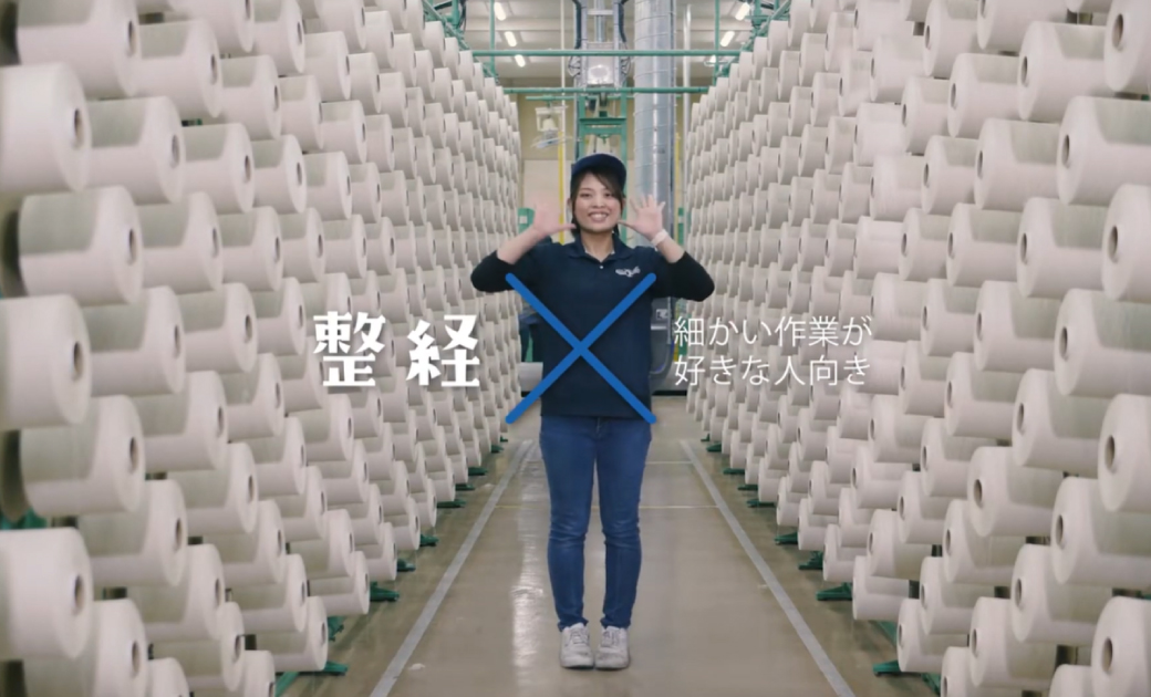 カイハラ株式会社の採用動画のワンシーン。整経を担当している社員が笑顔で立っている