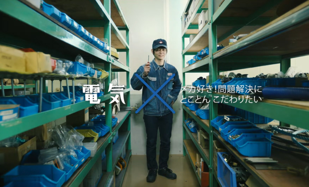 カイハラ株式会社の採用動画のワンシーン。電気を担当している社員が笑顔で立っている