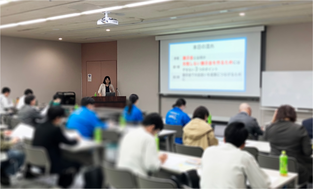 会議室で講義をしている女性と受講している人々