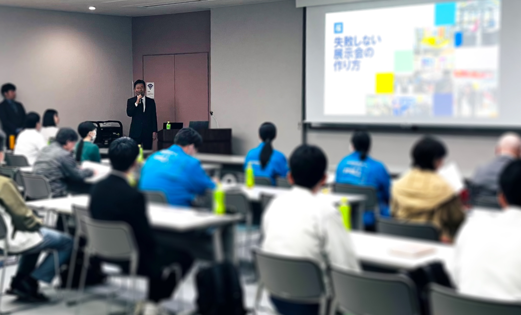会議室で講義をしている男性と受講している人々